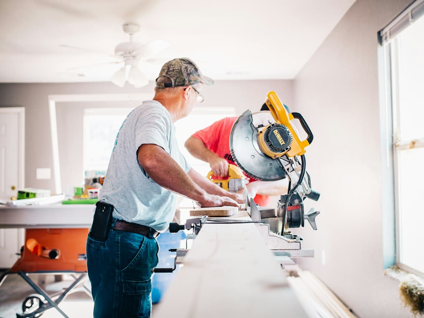Hantverkare som kapar list vid en kap- och gersåg i en villa under renovering